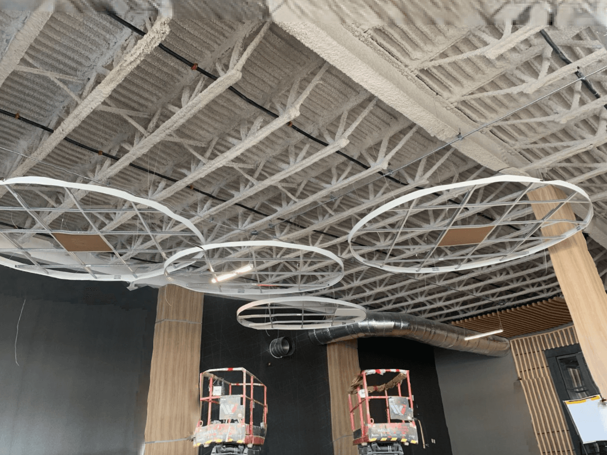 Circular ceiling features framed below an open-web steel roof